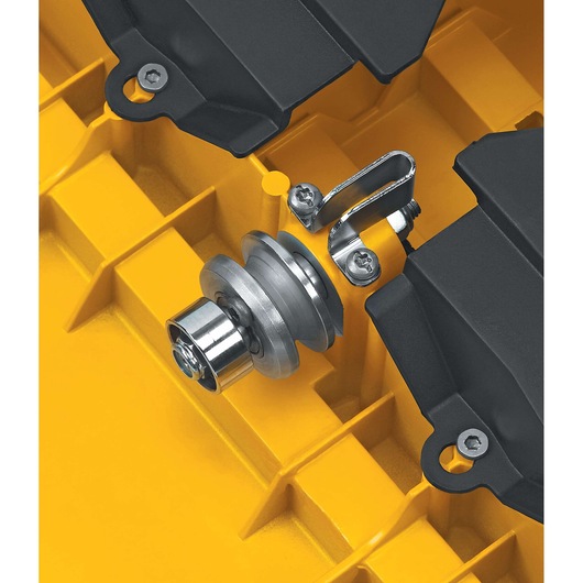 Close-up of a metal component and bracket mounted on a yellow DEWALT tool part, with black plastic housing and screws visible.