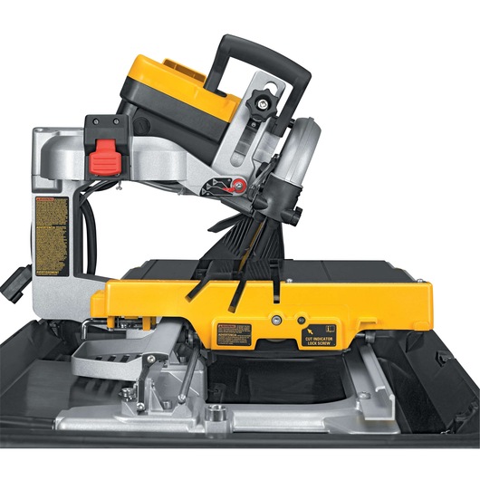 Close-up image of a DEWALT D24000 tile saw, featuring a yellow and black design with a water tray, adjustable cutting table, and mechanical blade. The saw is positioned for precision tile cutting.