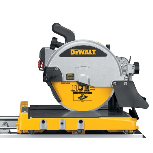 A DEWALT D24000 wet tile saw with a yellow and silver circular blade, shown mounted on a sliding rail and tile cutting table, designed for cutting materials like porcelain, slate, and granite.