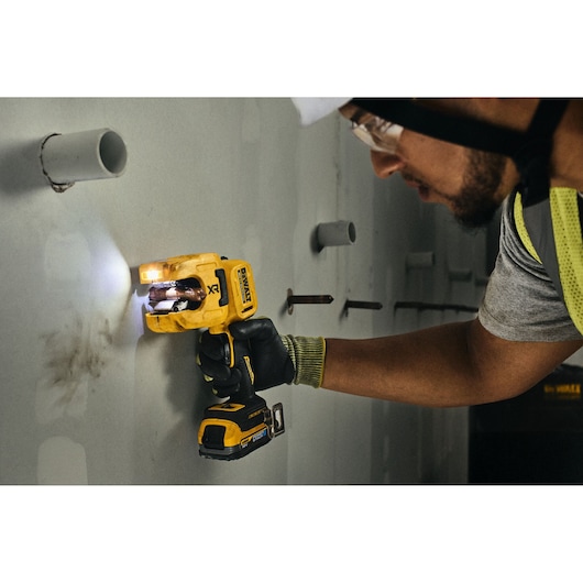 DEWALT DCE154N, DCE154N-XJ tool used on wall by worker; Photography category.