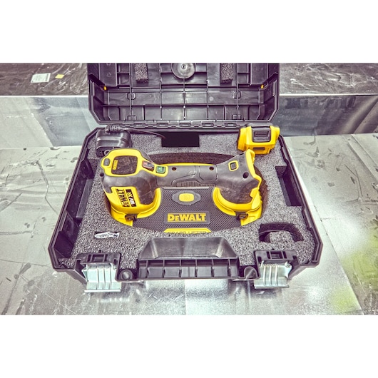A DEWALT power tool in a black carrying case with foam padding, showing the tool and its accessories securely arranged inside the box.
