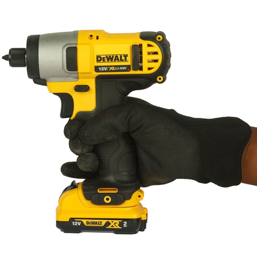 A close-up of a gloved hand holding a DEWALT 12V XR Li-Ion cordless impact driver against a white background.