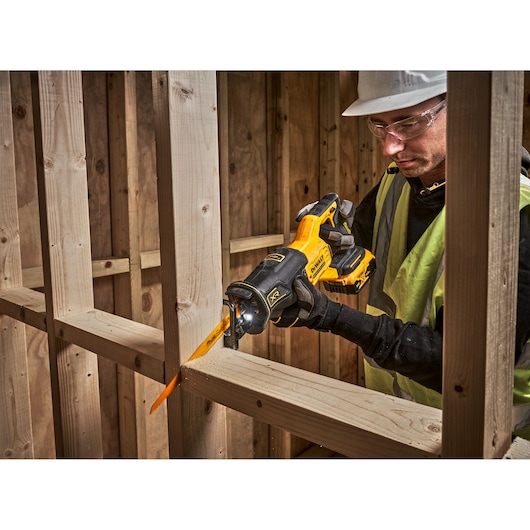 DEWALT DCS382N, DCS382N-XJ saw in use cutting wood at a construction site.