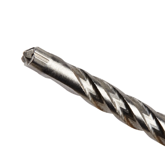Close-up of a metallic masonry drill bit with a spiral flute and pointed tip, designed for drilling into hard materials such as concrete or stone.