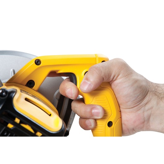 Close-up of a hand gripping the yellow handle of a DEWALT circular saw.