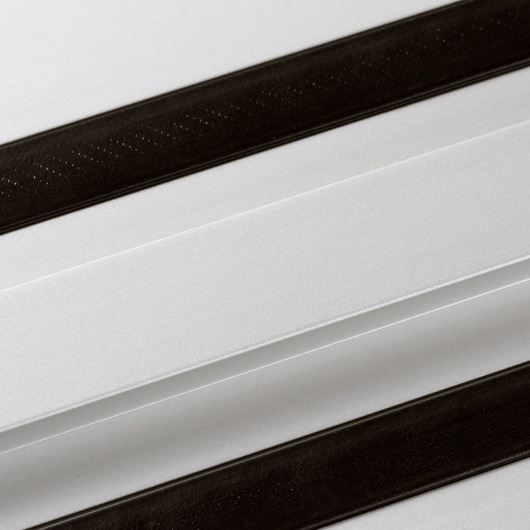 Close-up image of a DEWALT guide rail, showing two parallel black strips on a white or metallic surface. The product is used for precise guiding of power tools such as saws.