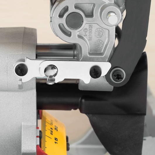 Close-up view of the mechanism and adjustment scale of a DEWALT DWS780 miter saw, showing metal components, screws, and a yellow measurement guide.