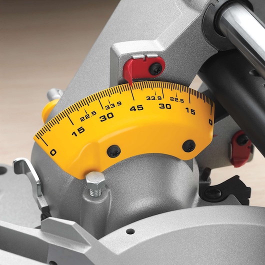 Close-up view of the angle measurement gauge on a DEWALT miter saw, with a yellow scale marked in degrees ranging from 0 to 45.