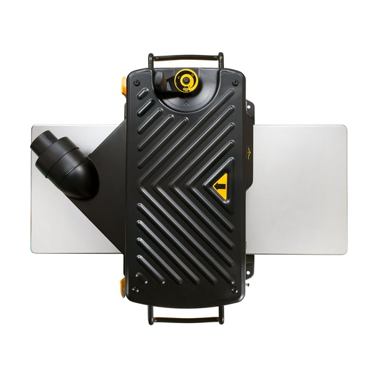 Top view of a DEWALT DW733 planer, featuring a black housing with diagonal grooves, a yellow adjustment knob, dust extraction port on the left, and silver-colored extension tables on both sides.
